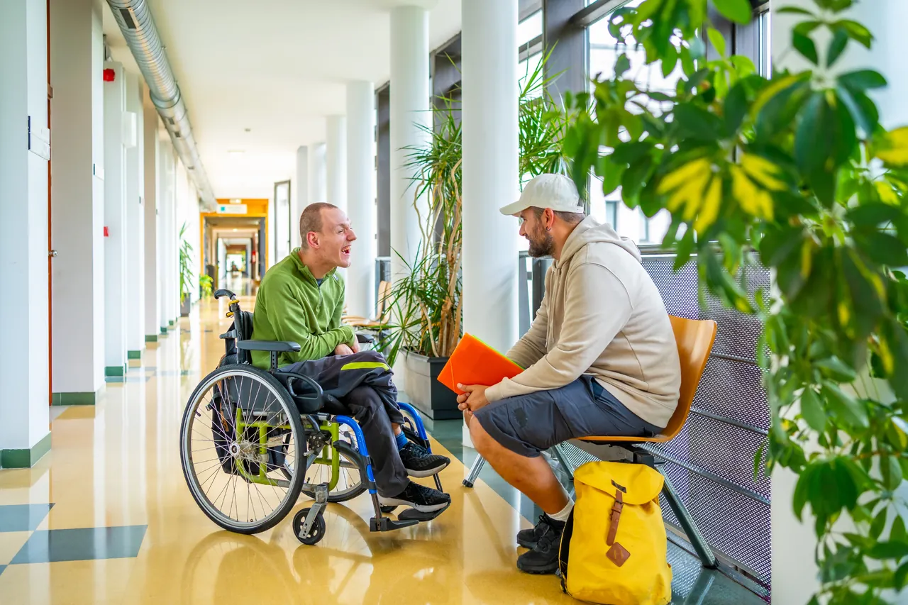 Two people having a conversation in a bright communal space