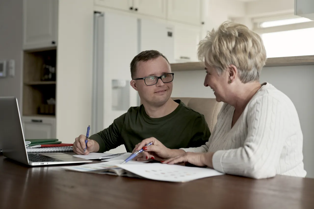 Two people looking through paperwork together at home